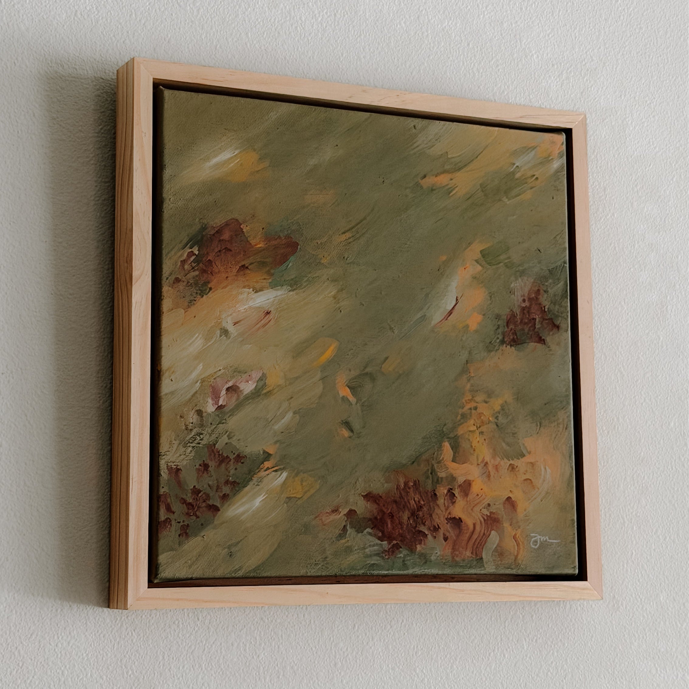 Framed abstract painting on a plain wall