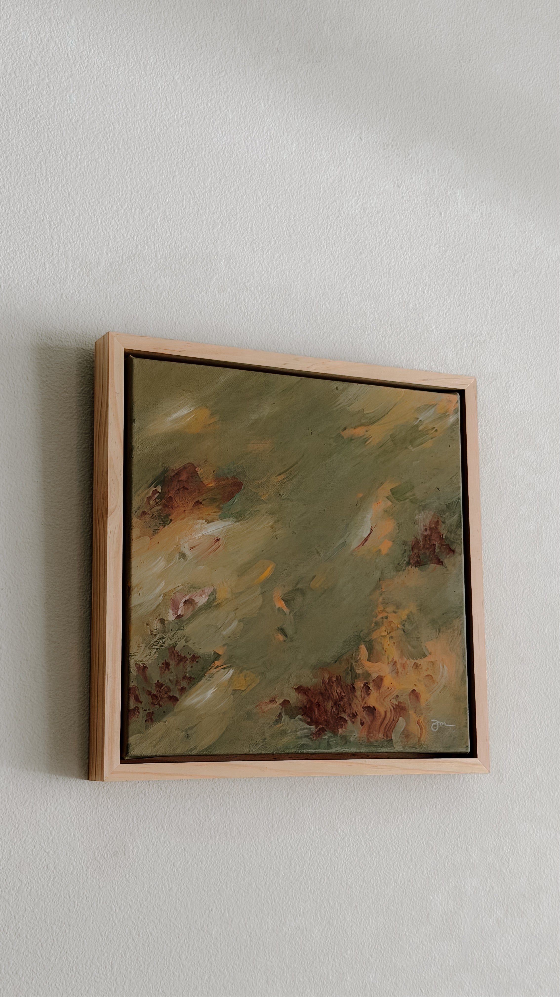 Framed painting with abstract design on a plain wall